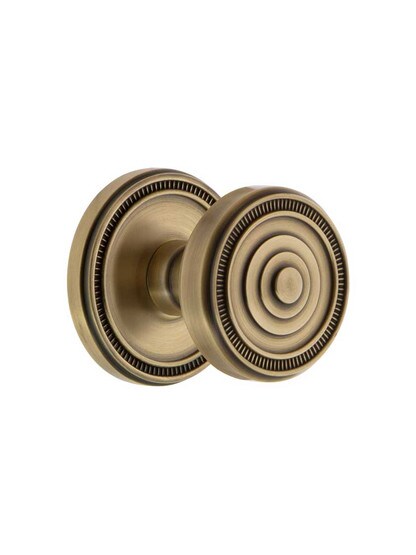 Grandeur Soleil Rosette Door Set with Soleil Knobs in Antique Brass.